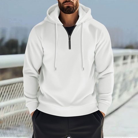 Man in a white half-zip waffle hoodie standing outdoors