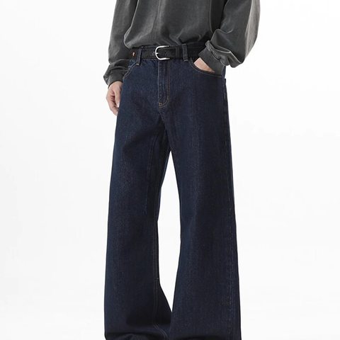 Model in dark raw indigo wide-leg jeans with a belt