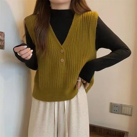 Model in a mustard ribbed V-neck knit vest over a black top